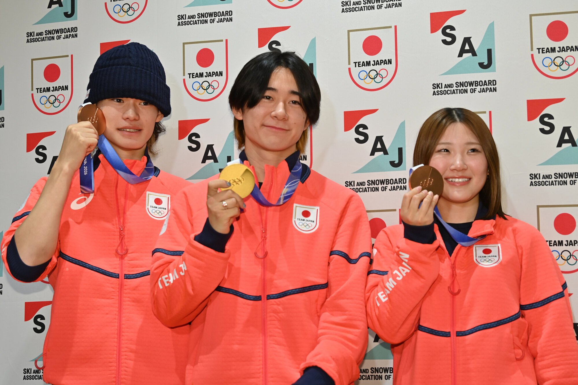 帰国し、会見でメダルを見せるスノーボード出場の(左から)山田琉聖、戸塚優斗、小野光希=2026年2月17日午後1時59分、羽田空港、菊池康全撮影