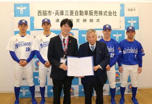 締結書を手にする片山西脇市長(左から3人目)と西原兵庫三菱自動車販代表取締役社長兼会長(同4人目)と選手ら(撮影･林亮佑)