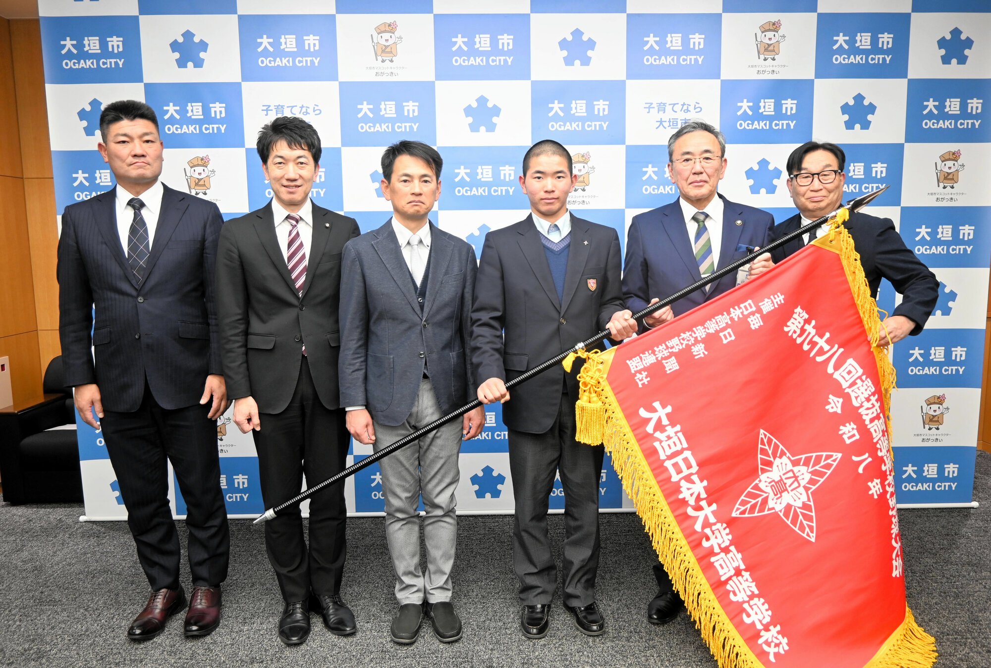 記念撮影をする大垣日大の山崎智貴主将(右から3人目)や高橋正明監督(同4人目)=2026年2月18日、岐阜県大垣市役所、高原敦撮影