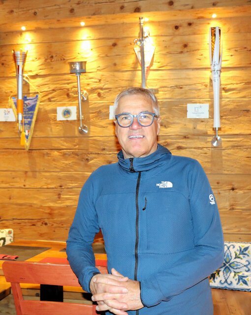 聖火のトーチが壁に飾られているコルティナダンペッツォのレストラン｢アル･パセット｣の店主、ジョルジオ･ゲディーナさん