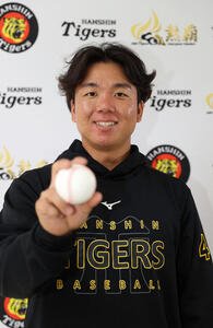 宜野座でインタビューした阪神村上はボールを手に笑顔を見せる(撮影･上山淳一)