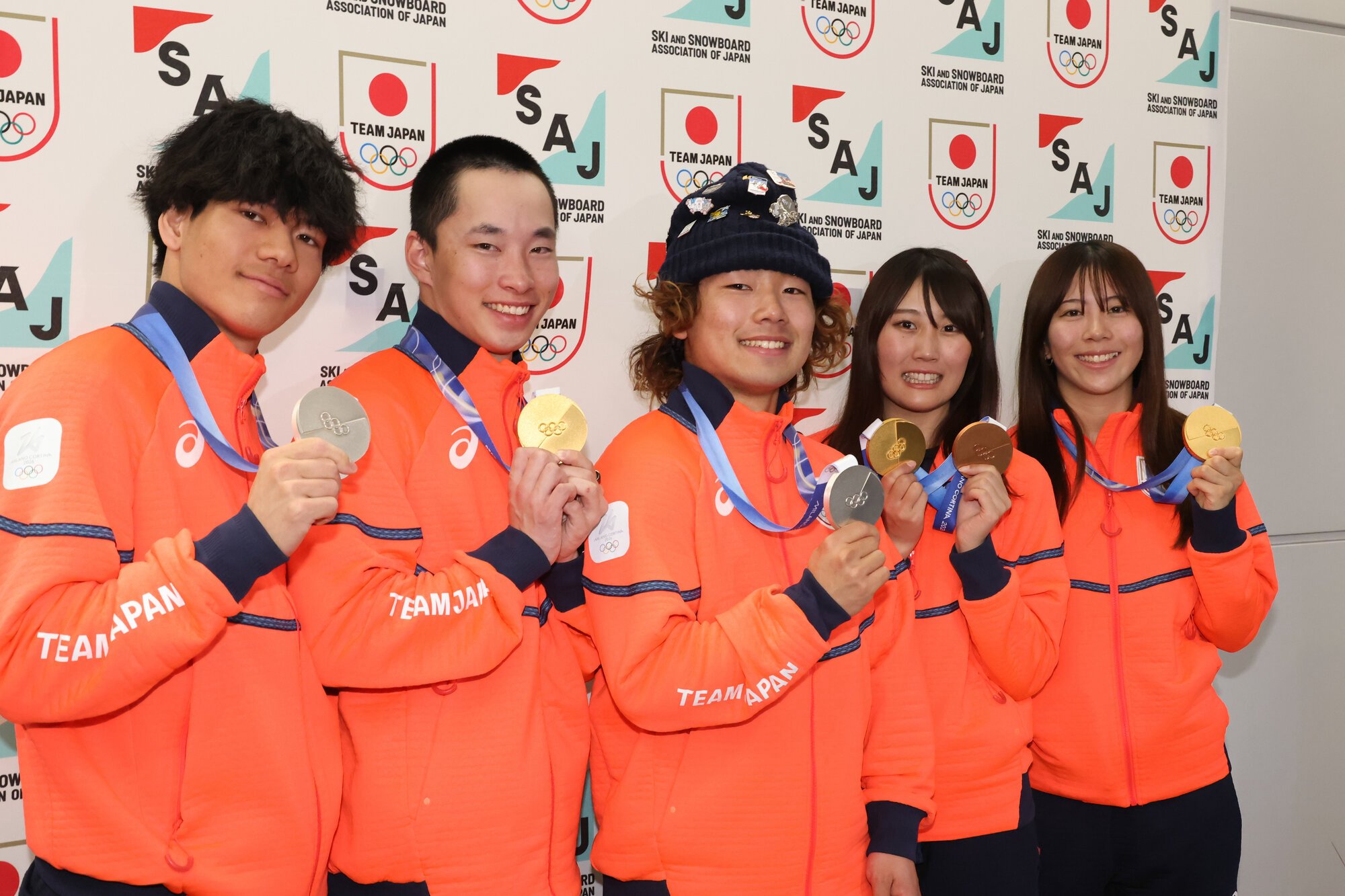 ミラノ･コルティナ冬季五輪を終えて帰国し、取材対応でメダルを掲げる(左から)木俣椋真、木村葵来、長谷川帝勝、村瀬心椛、深田茉莉=2026年2月22日午後4時12分、成田空港、上田幸一撮影