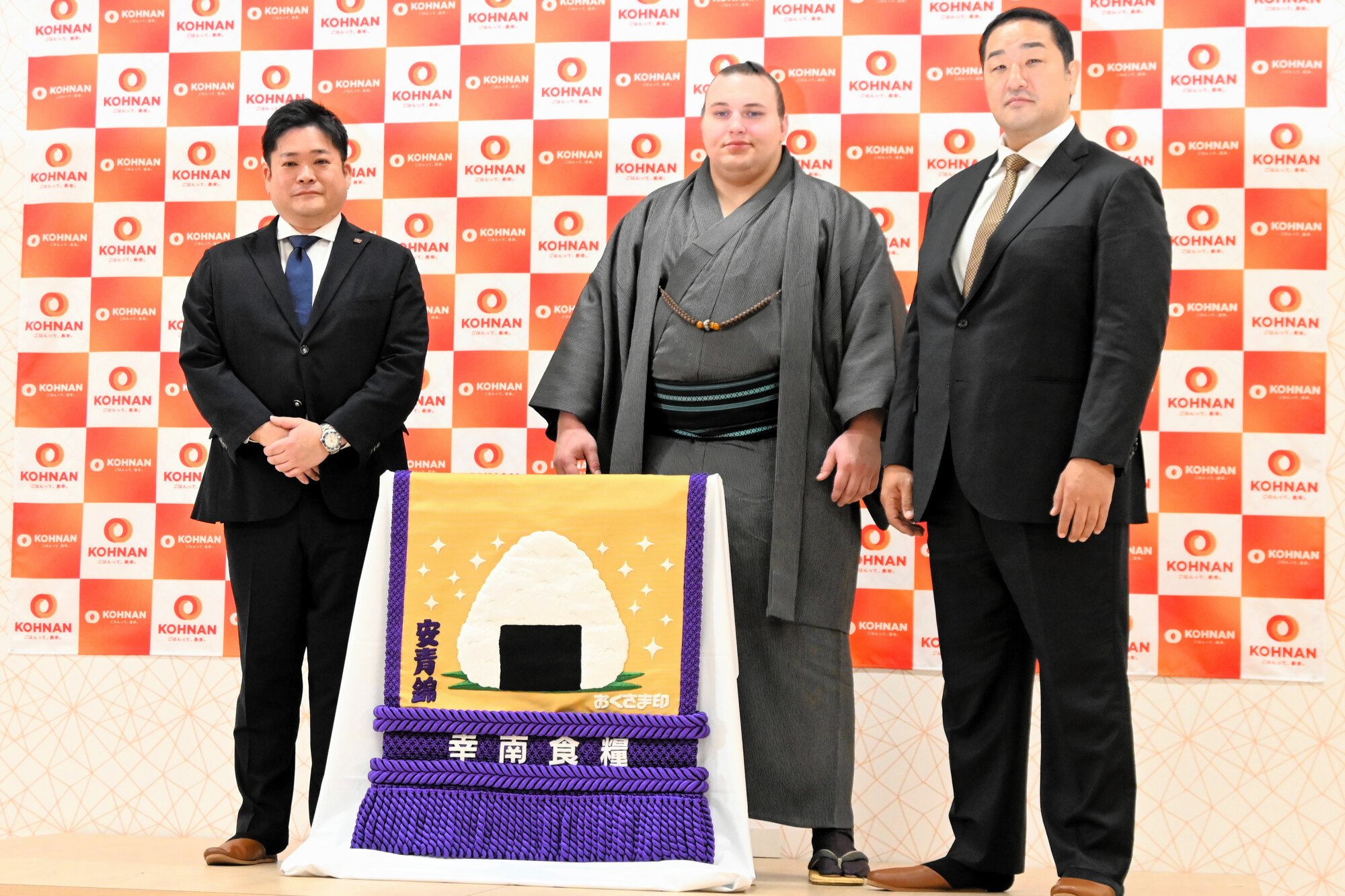 新しい化粧まわしを贈られた安青錦(中央)=大阪府松原市