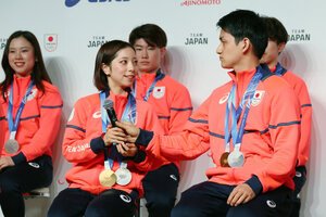 会見で三浦璃来選手(左)にマイクを渡す木原龍一選手=2026年2月24日午後4時3分、東京都江東区、吉本美奈子撮影