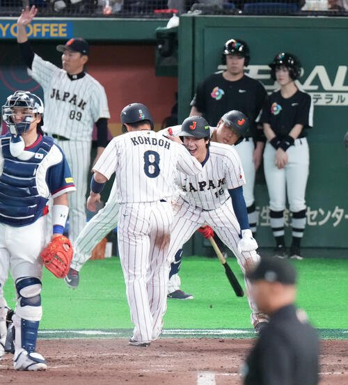 日本対韓国　7回裏日本2死満塁、吉田の2点適時打で生還した二塁走者近藤(手前)を迎える三塁走者大谷(撮影･鈴木みどり)