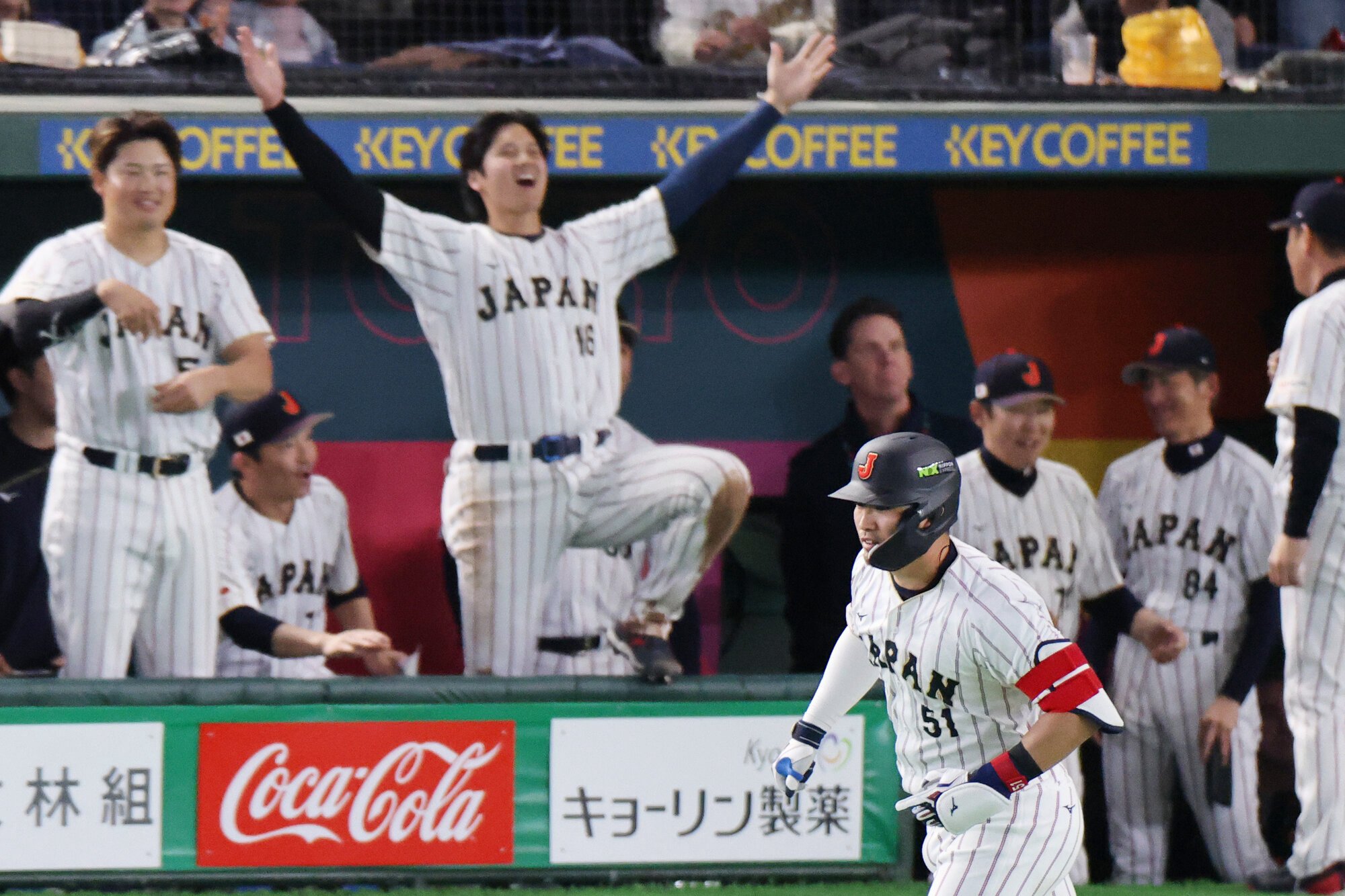 三回裏日本2死、鈴木誠也(手前右下)は勝ち越し本塁打を放ち一塁へ向かう。後方中央左は両手を広げて喜ぶ大谷翔平=友永翔大撮影