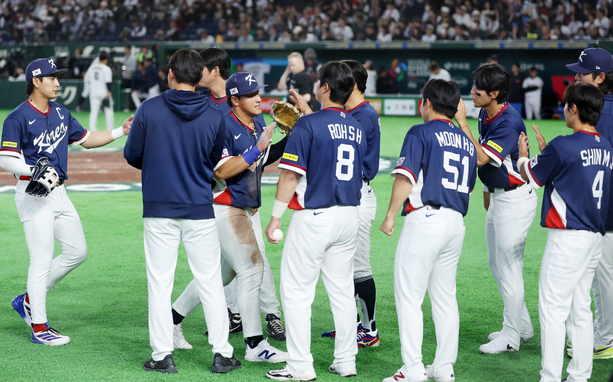 五回裏を無失点に抑えてベンチに戻る韓国の選手たち、出迎える選手たち＝金居達朗撮影