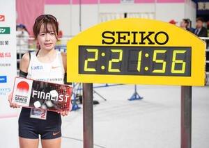 全体2位の日本選手トップでゴールしタイムボード横で写真に納まる佐藤早也伽(撮影･森本幸一)