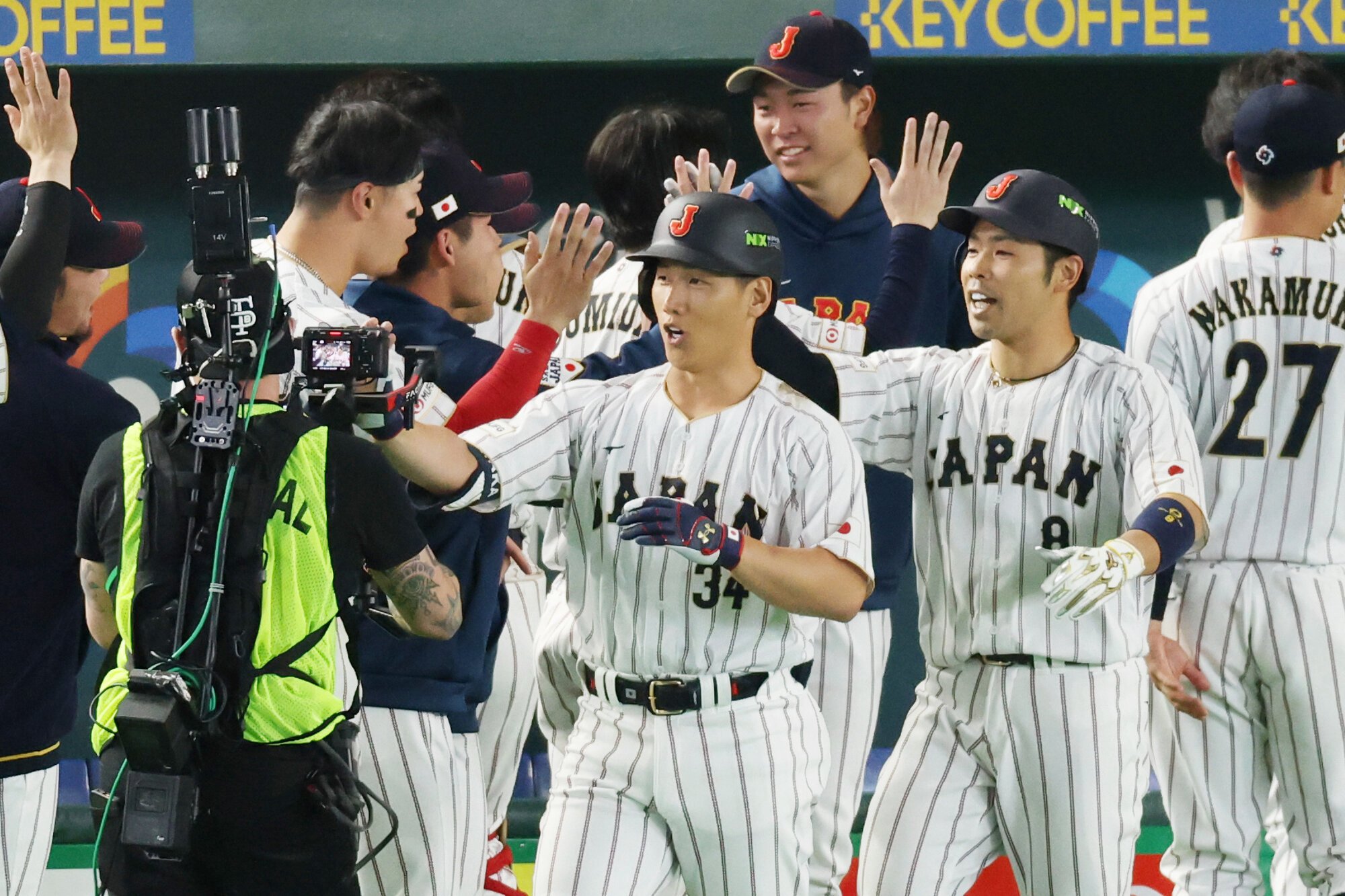七回裏日本2死一塁、吉田正尚(中央)は逆転の2点本塁打を放ち、ベンチ前で祝福される=内海日和撮影