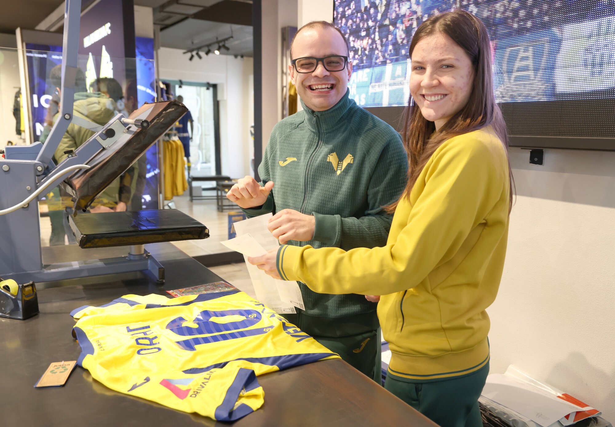 他のスタッフとユニホームをたたみ、袋詰めするエンリコ･バッレストラさん(左)。いつも笑顔があふれる=2026年3月5日、イタリア･ベローナ、吉田耕一郎撮影