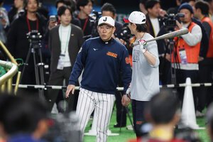 試合前、練習中に周東佑京(右)と話をする井端弘和監督=金居達朗撮影