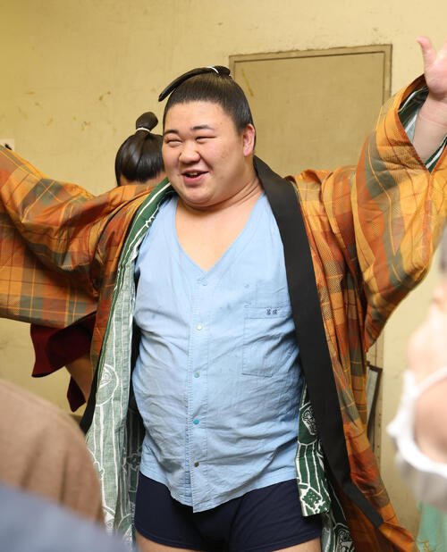 支度部屋で藤ノ川は笑顔で着替える