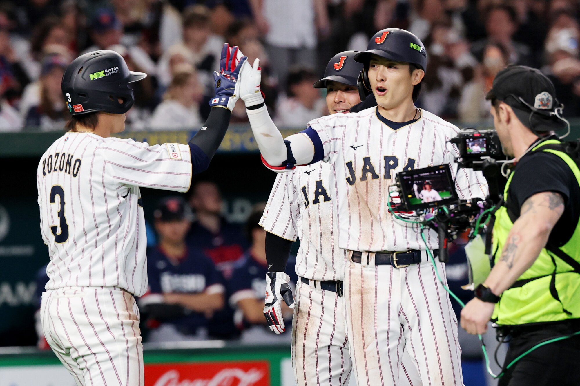 八回裏日本2死一、二塁、周東佑京は右中間に3点本塁打を放ち、一塁走者小園海斗③とハイタッチ=友永翔大撮影