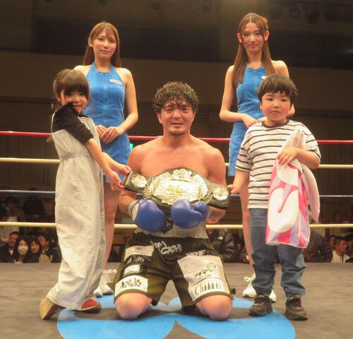 2人の子供、ラウンドガールとともに日本スーパーウエルター級王座ベルトを掲げる同級王者左右田泰臣(前列中央)