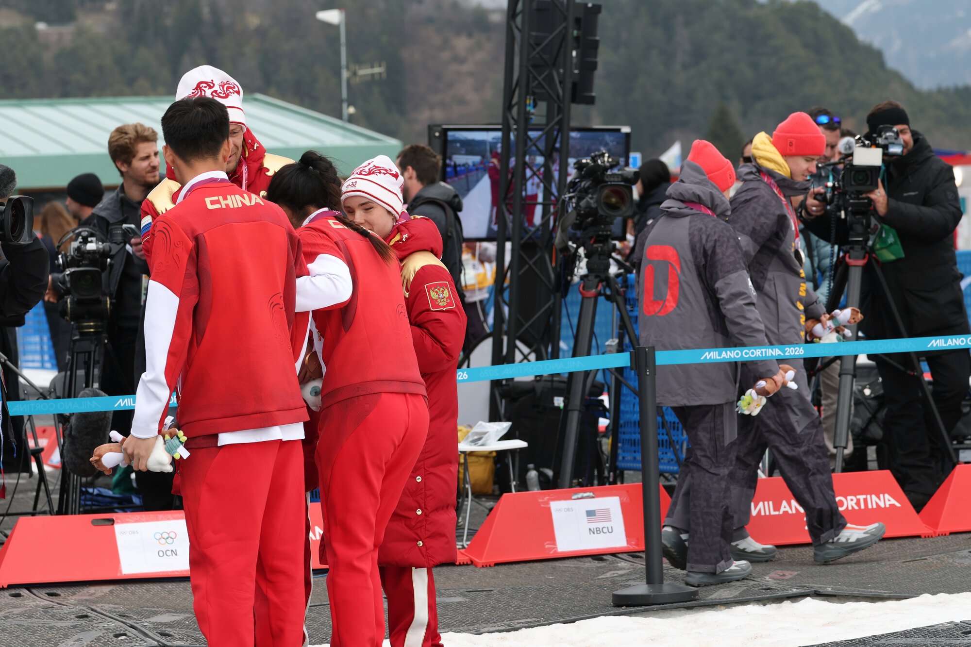 距離女子スプリント･クラシカル視覚障害の表彰式で、ロシアや中国選手との｢自撮り撮影｣に参加せず退場するドイツの選手ら(右)=吉田耕一郎撮影