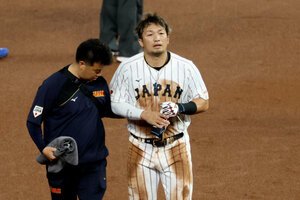 一回裏日本2死一塁、走者鈴木誠也は二盗を狙うもタッチアウト、足を痛めて厳しい表情でベンチに戻る=金居達朗撮影