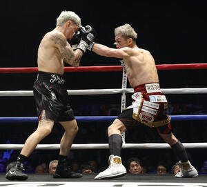 1回、オラスクアガ(左)の顔面にパンチを見舞う飯村(撮影･山本朝陽)