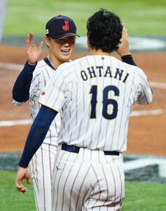 日本対ベネズエラ　4回裏ベネズエラの攻撃を無失点に抑えた山本(中央)は大谷と笑顔でタッチを交わす(撮影･垰建太)