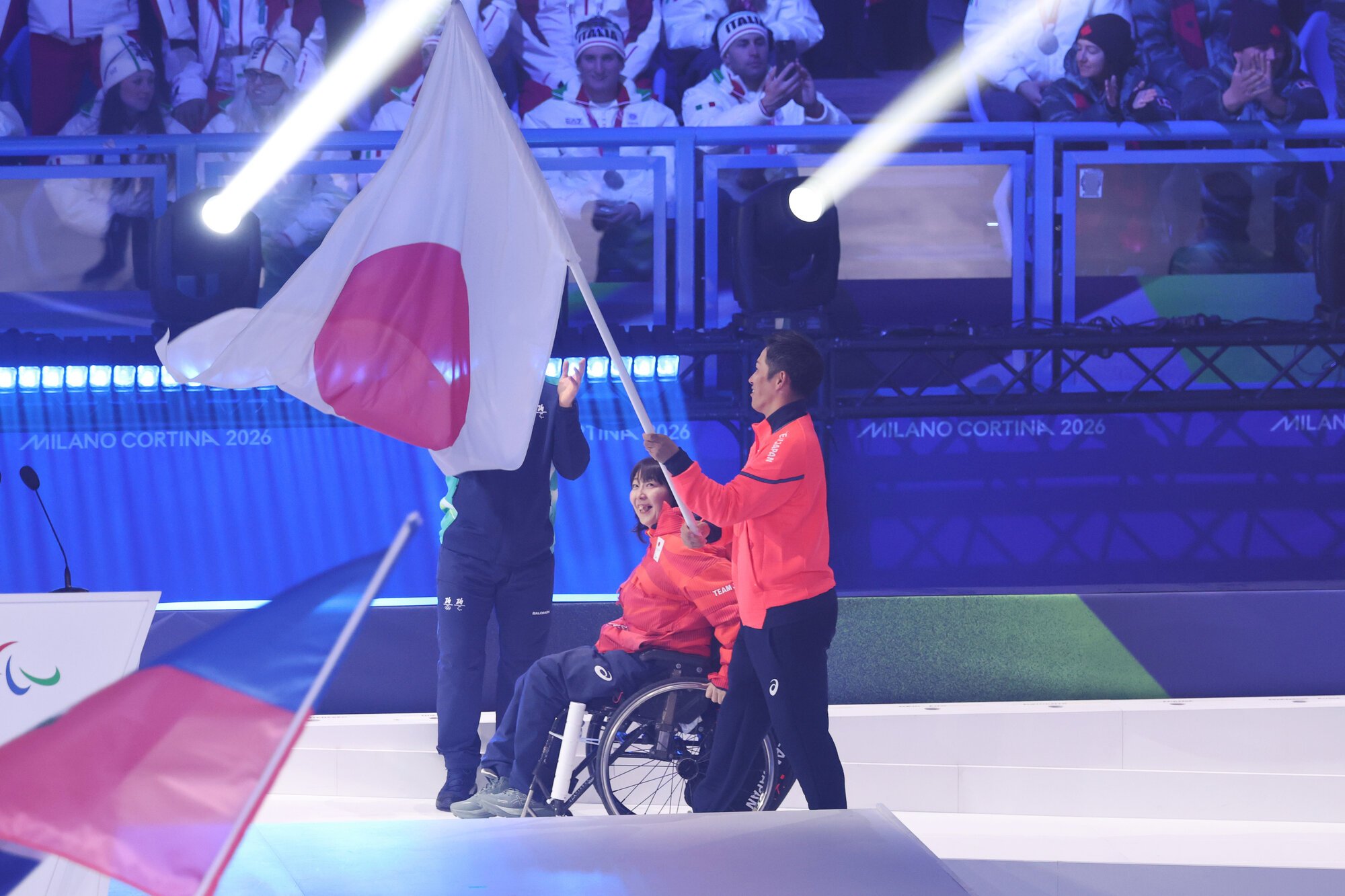 閉会式で日本の旗手を務める車いすカーリングの小川亜希(左)とスノーボードの小須田潤太=2026年3月15日夜、イタリア･コルティナダンペッツォ、井手さゆり撮影