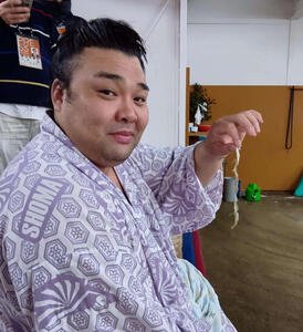 稽古場で発見した白いヘビの抜け殻を手に、吉兆と喜ぶ霧島