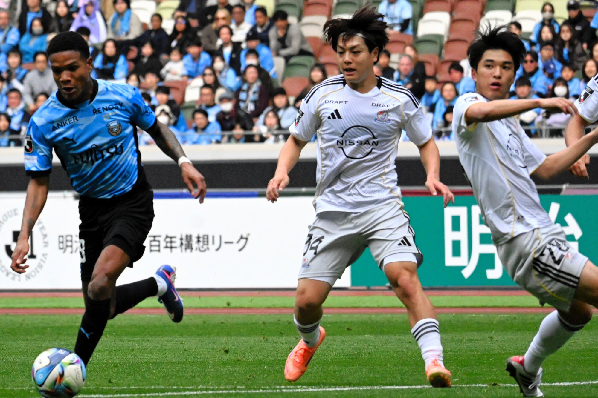 前半、自陣ゴール前で守備をする横浜マの木村卓(中央)と山根(右)