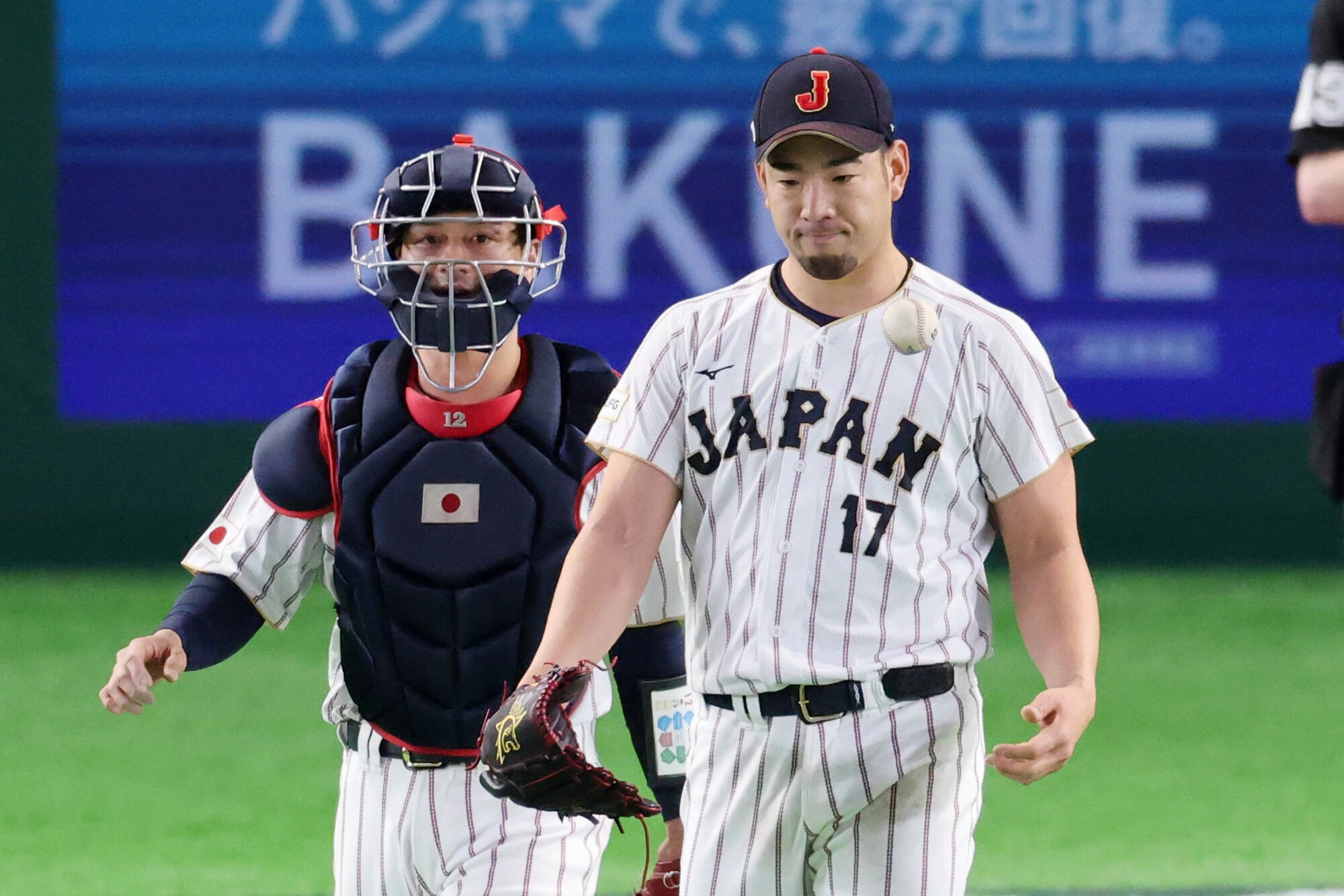 7日の韓国戦で先発した菊池雄星(右)の元に駆け寄る捕手の坂本誠志郎=友永翔大撮影