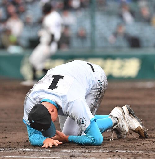 山梨学院対長崎日大　5回裏長崎日大2死一塁、三塁からの悪送球で打者の平野と交錯し左手を痛めた一塁手の山梨学院･菰田(2026年3月撮影)