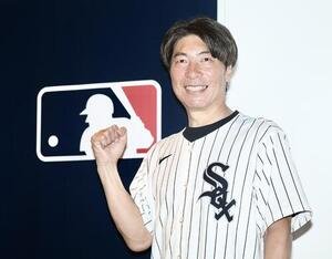 笑顔で写真に納まる高津臣吾氏(撮影･河田真司)