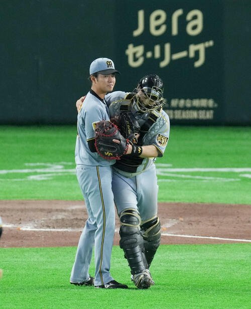 巨人対阪神　ピンチを抑え勝利し笑顔で抱き合う伏見(右)と高橋(撮影･増田悦実)