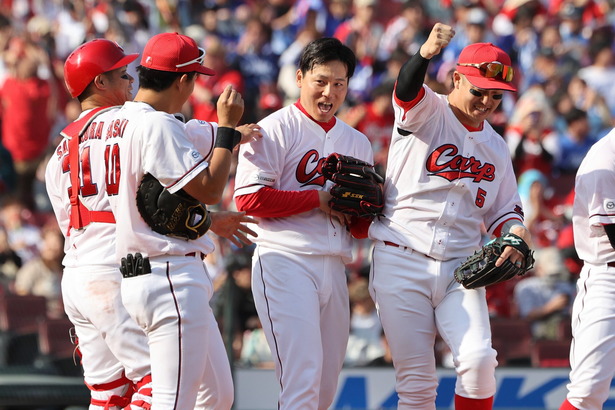 プロ初先発で完封勝利を挙げ、笑顔を見せる広島の栗林(右から2人目)=上田潤撮影