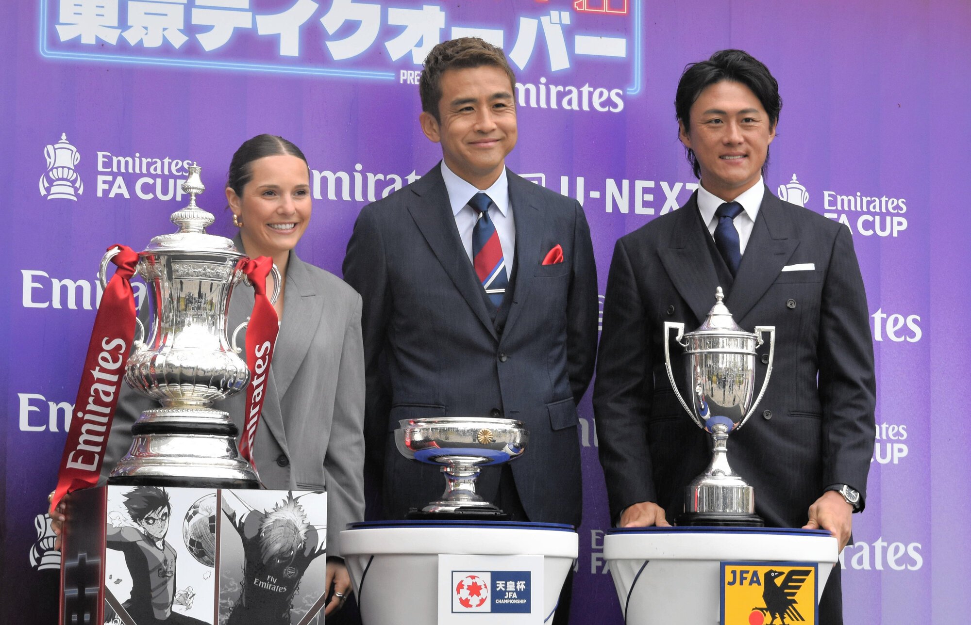 日本とイングランドにゆかりのある三つのカップと、記念撮影に応じる稲本潤一さん(中央)、李忠成さん(右)