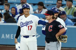 ガーディアンズとの初戦の一回裏、左前安打を放ち、塁上で笑顔を見せるドジャースの大谷翔平(左)＝金居達朗撮影