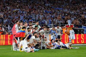 スペイン国王杯を制し、ピッチに座って記念撮影するレアル･ソシエダードの久保建英(前列左から3人目)ら(AP)