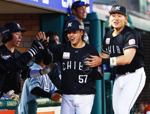 楽天対ロッテ　8回表ロッテ1死満塁、敵失で生還した小川はナインとハイタッチ。右は山本(撮影･野上伸悟)