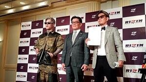 壇上で平本蓮(左)、皇治(右)と並ぶ榊原信行CEO
