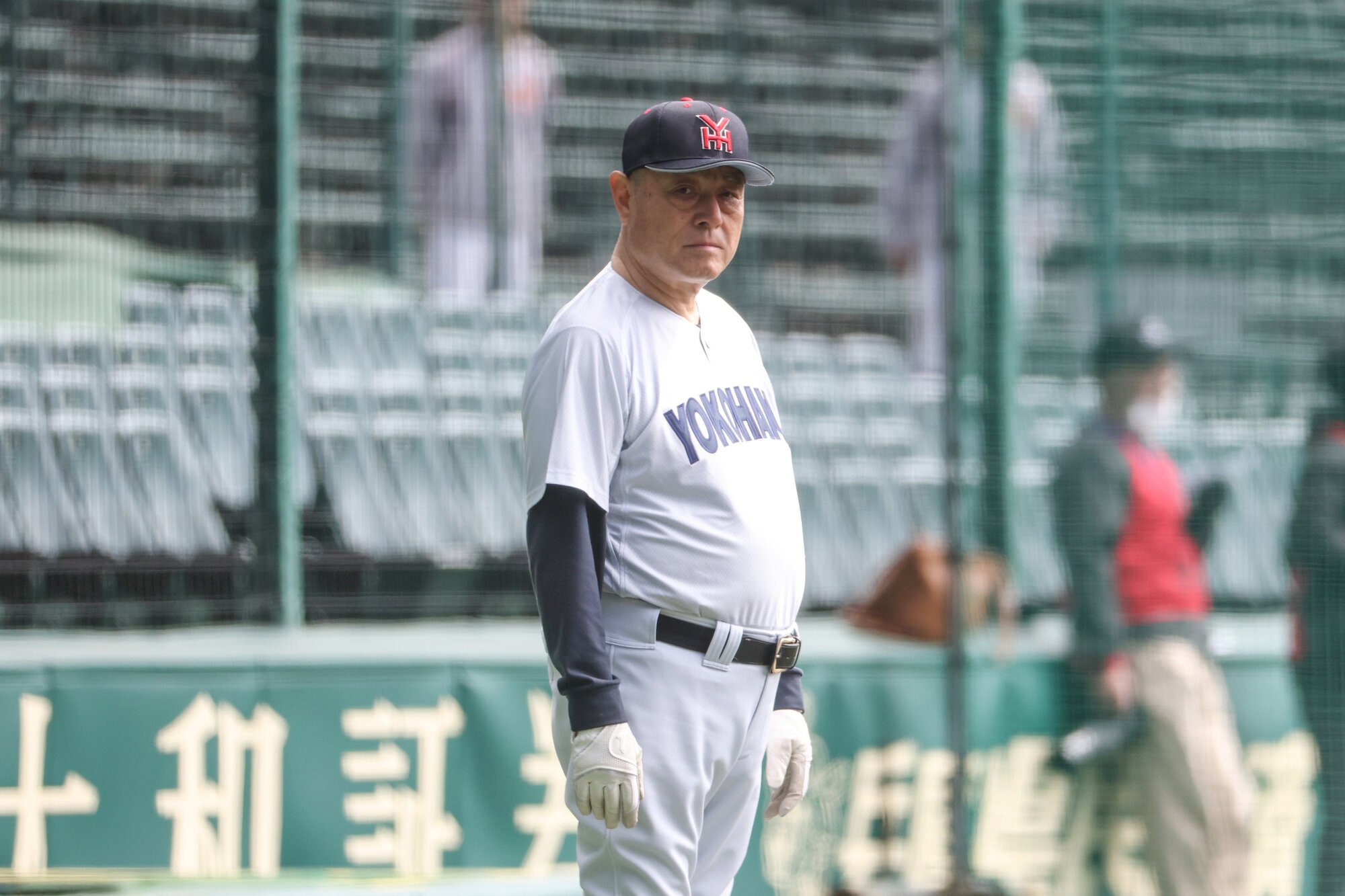 阪神甲子園球場で選手の練習を見る横浜特別顧問の名塚徹さん=2026年3月14日午後、米田怜央撮影