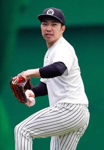 SGLスタジアムの室内でキャッチボールする阪神石井大智(撮影･上山淳一)