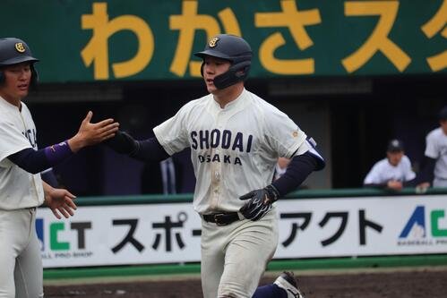 大院大対大商大　3回、第3打席で本塁打を放ち仲間とタッチを交わす大商大･春山陽登