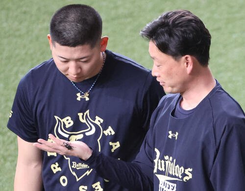 5日、オリックス対ロッテ　試合前の練習でオリックス岸田護監督は外野でニジイロクワガタを採集。左は見入る椋木蓮(撮影･西尾就之)