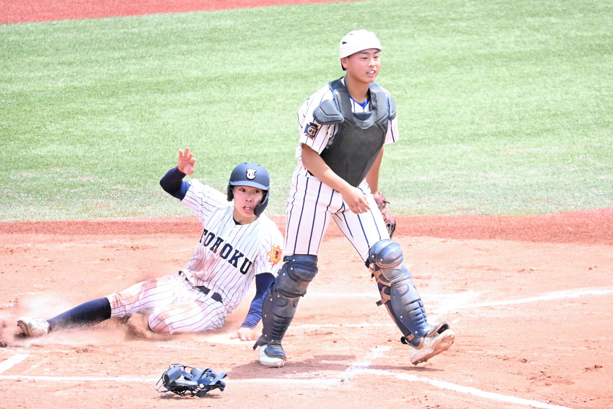 東北学院榴ケ岡―東北　六回、本塁に生還する東北の松本。捕手遠藤=2026年5月23日午前11時23分、石巻市民、三村悠撮影