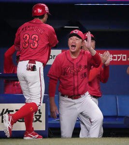 中日対広島　6回表広島1死一塁、新井貴浩監督(右)は2点本塁打を放った菊池涼介を迎える(撮影･森本幸一)