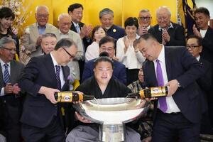 大相撲夏場所千秋楽　優勝祝賀会会場で後援会関係者から祝福を受けながらお祝いのお酒が注がれた銀杯を手にする若隆景(中央)。右は荒汐親方(撮影･小沢裕)