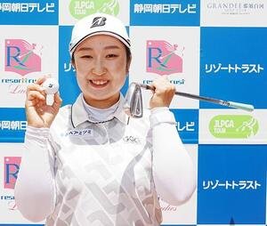 リゾートトラストレディース第2日　8番ショートでホールインワンを達成した阿部未悠はプレー終了後に7番アイアンとボールを手に笑顔を見せる(撮影･小沢裕)