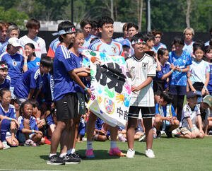 サッカー日本代表W杯北中米大会ベースキャンプ　現地の子どもたちから応援メッセージの入った横断幕を受け取る遠藤航(右)(撮影･足立雅史)