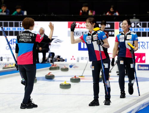 日本カーリング選手権大会　横浜2026　女子プレーオフ　中部電力対フォルティウス　第4エンド、笑顔でハイタッチをするフォルティウスの小林未奈(中央)(撮影･山本朝陽)