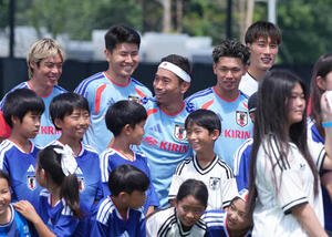 練習前、現地の子どもたちと笑顔でふれあう、後方左から伊東純也、鈴木淳之介、長友佑都、塩貝健人、GK大迫敬介(撮影･足立雅史)