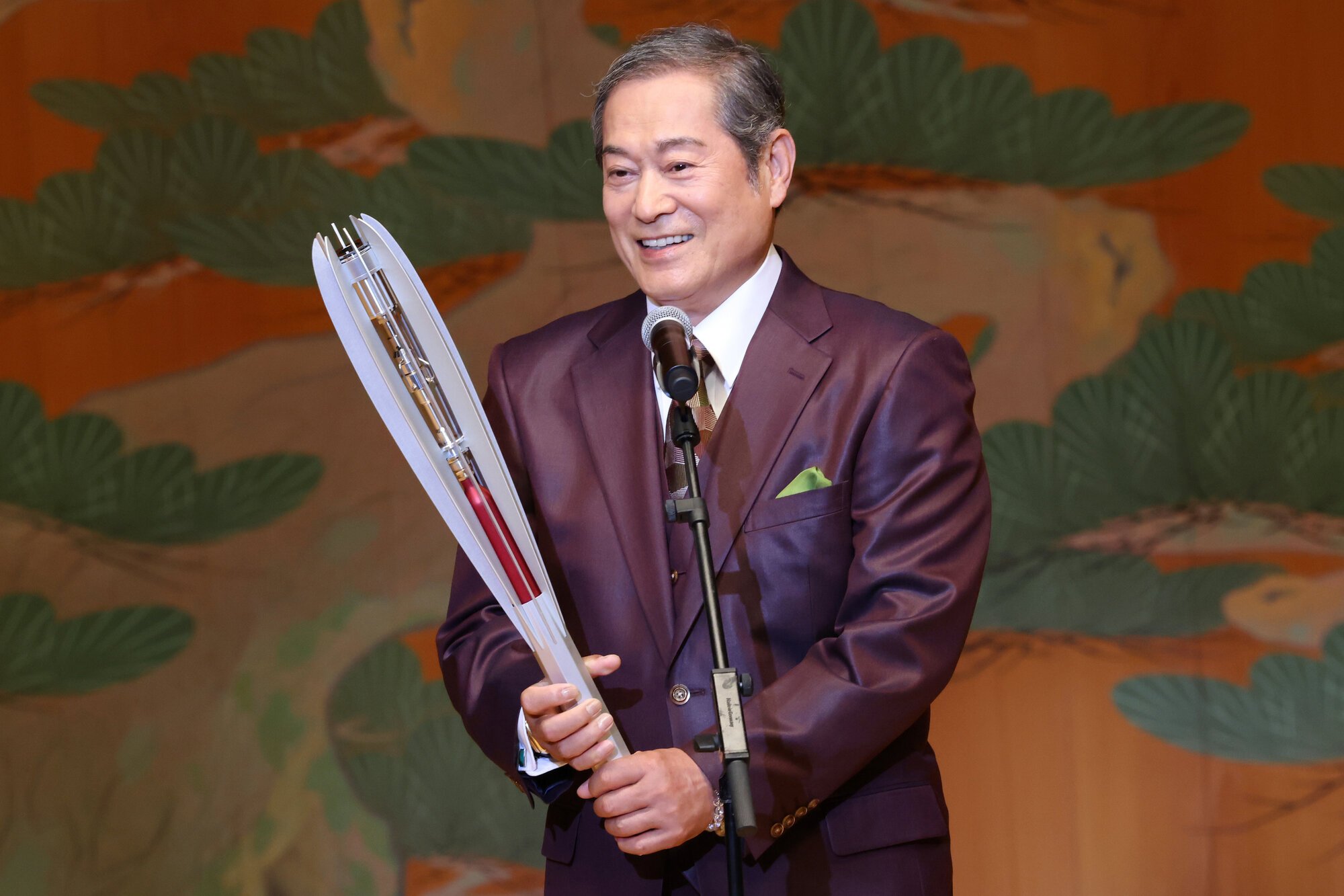 11日の式典で大会公式アンバサダーの松平健さんが披露した聖火リレーのトーチ=2026年6月11日午前10時51分、名古屋市中区の名古屋能楽堂、溝脇正撮影