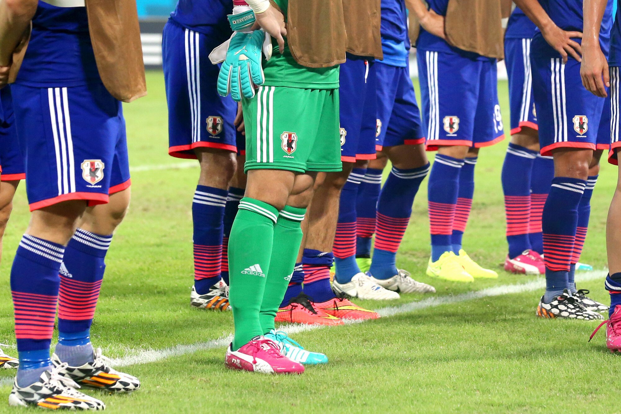 2014年のW杯ブラジル大会に出場した日本代表選手たちの足元。テープを巻いていたり、足首のところで靴下の色が変わっていたりする選手はセパレートソックスをはいているとみられる=上田潤撮影