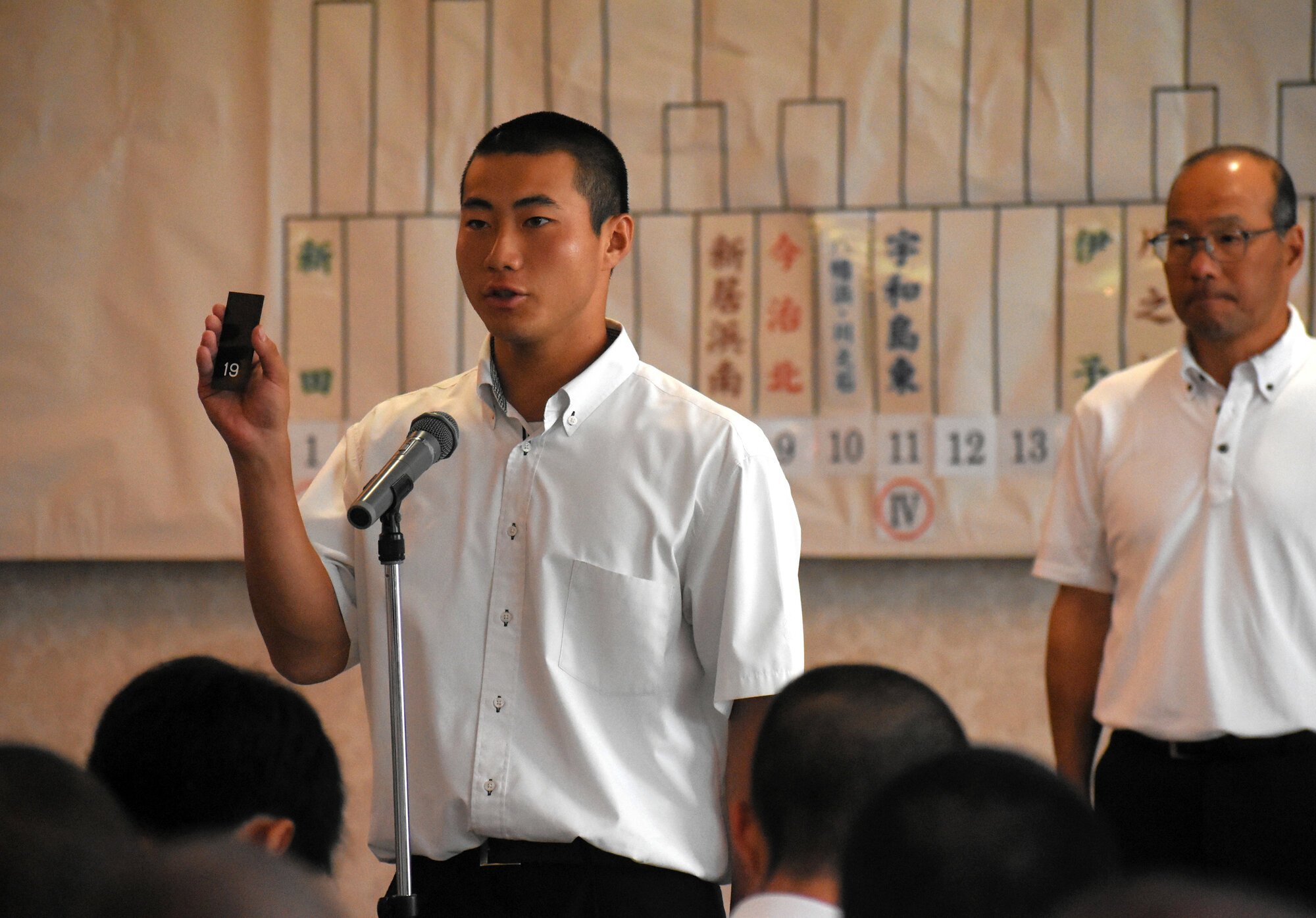 引いた抽選札の番号を読み上げる選手=2026年6月21日午前10時29分、松山市道後姫塚、水田道雄撮影