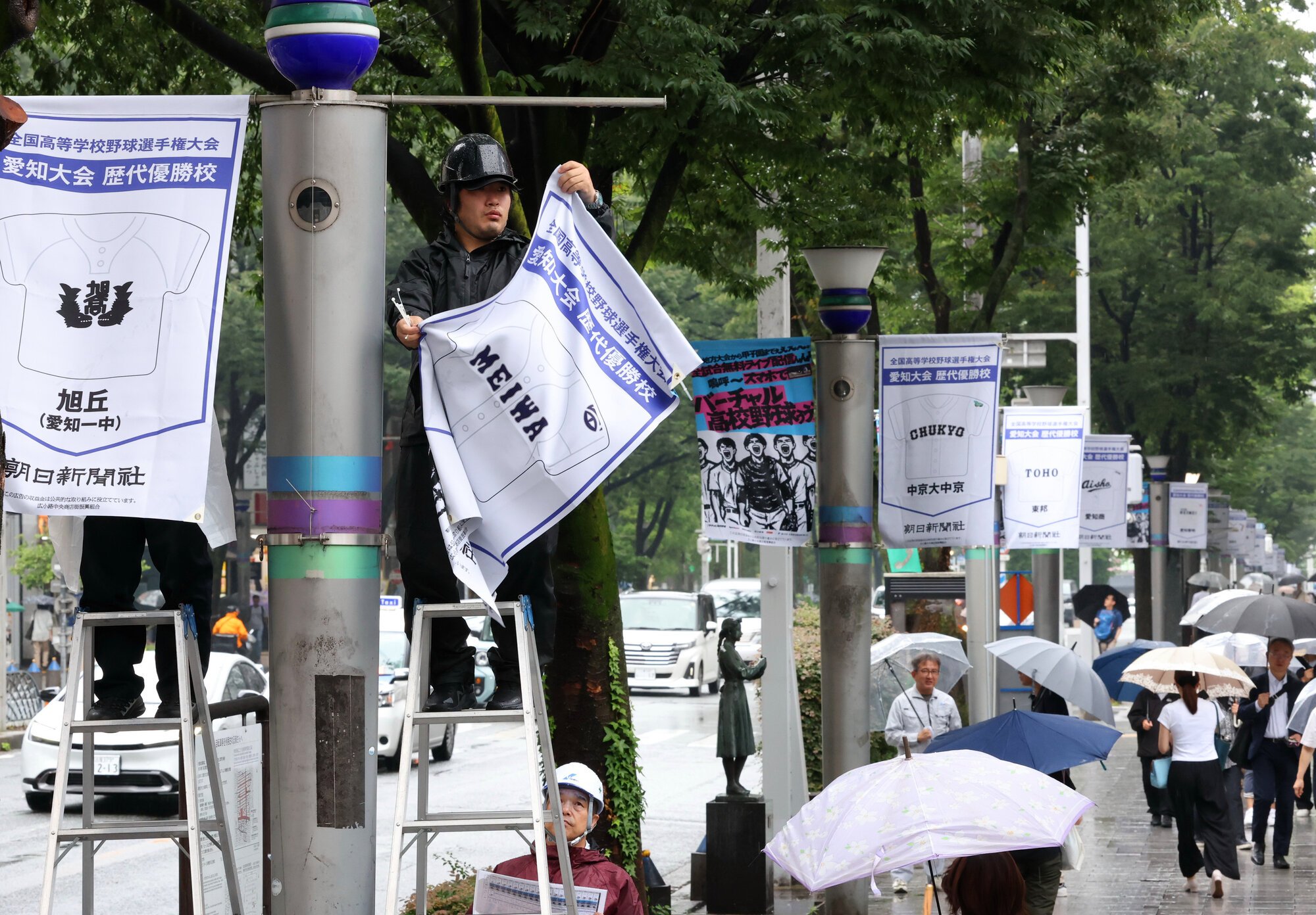 広小路通の街路灯に取り付けられた、愛知大会歴代優勝校や出場校のユニホームなどをデザインしたフラッグ広告=2026年6月25日午前10時13分、名古屋市中区、溝脇正撮影